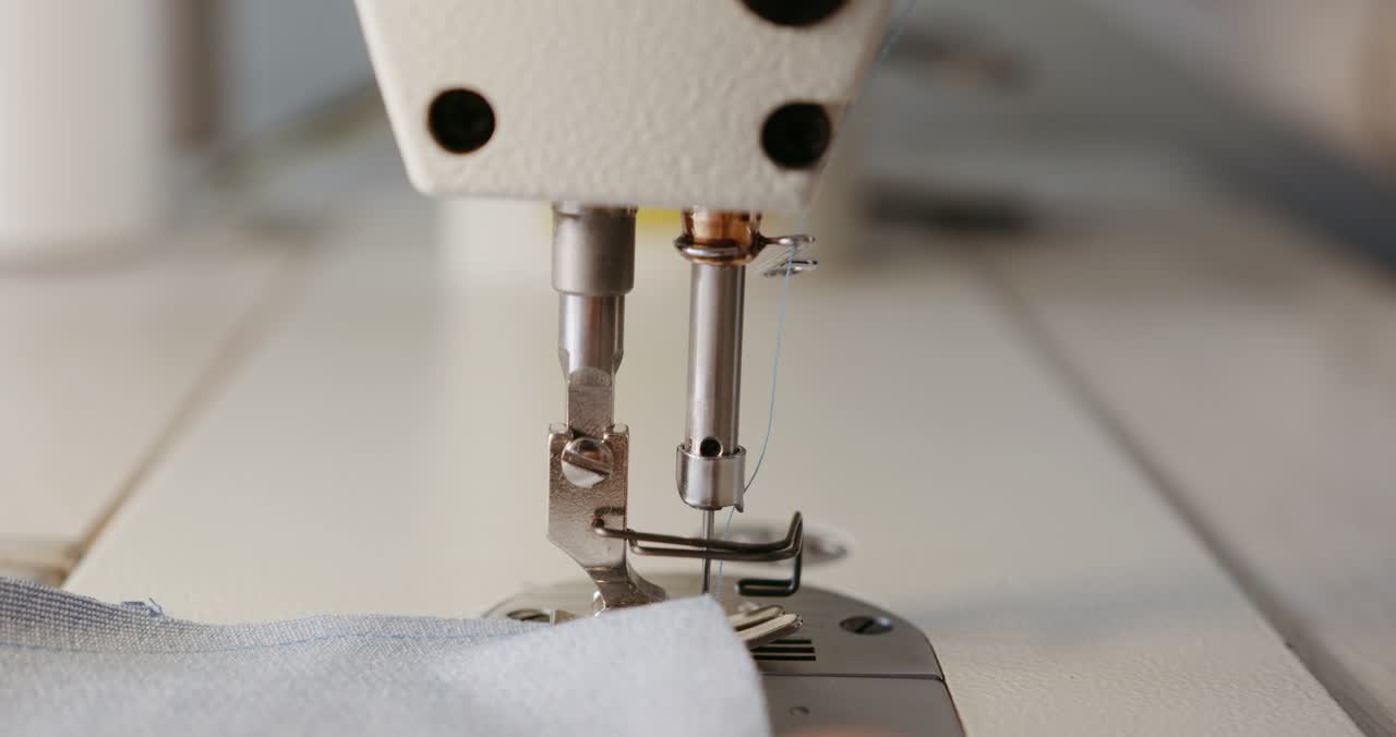 Nähmaschine näht eine Naht über hellen Stoff